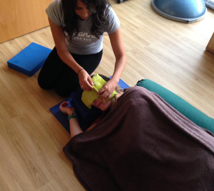 Rebecca helps Chantelle get ready for relaxation after her pregnancy yoga class